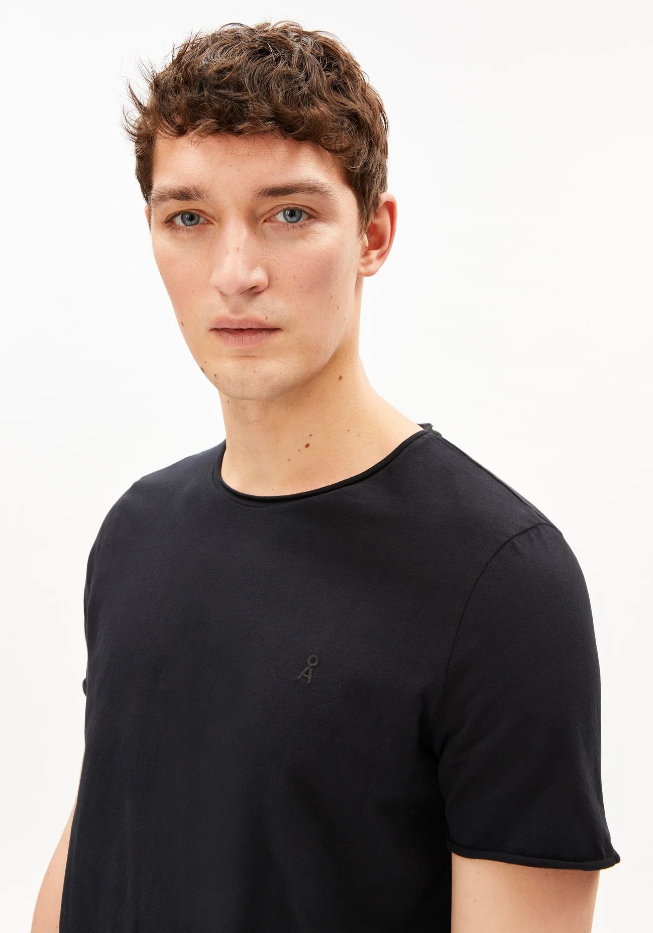 Men's black t-shirt organic cotton JAAMES BRUSHED T-SHIRT in Black - ARMEDANGELS Canada close-up detail fo collar and sleeve on model in Kelowna