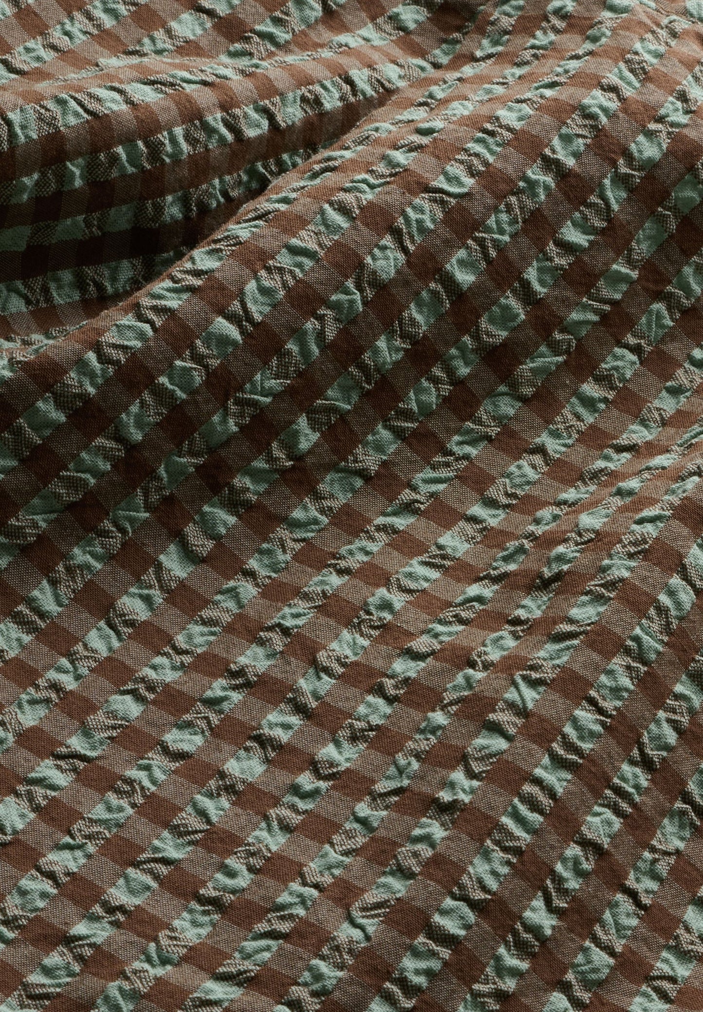 Detail shot of brown and green checkered vichy seersucker fabric
