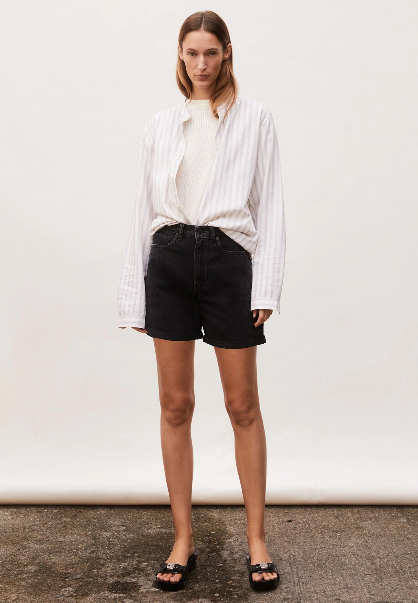 Woman wearing a white shirt and black shorts against a plain background for Kelowna and Canada