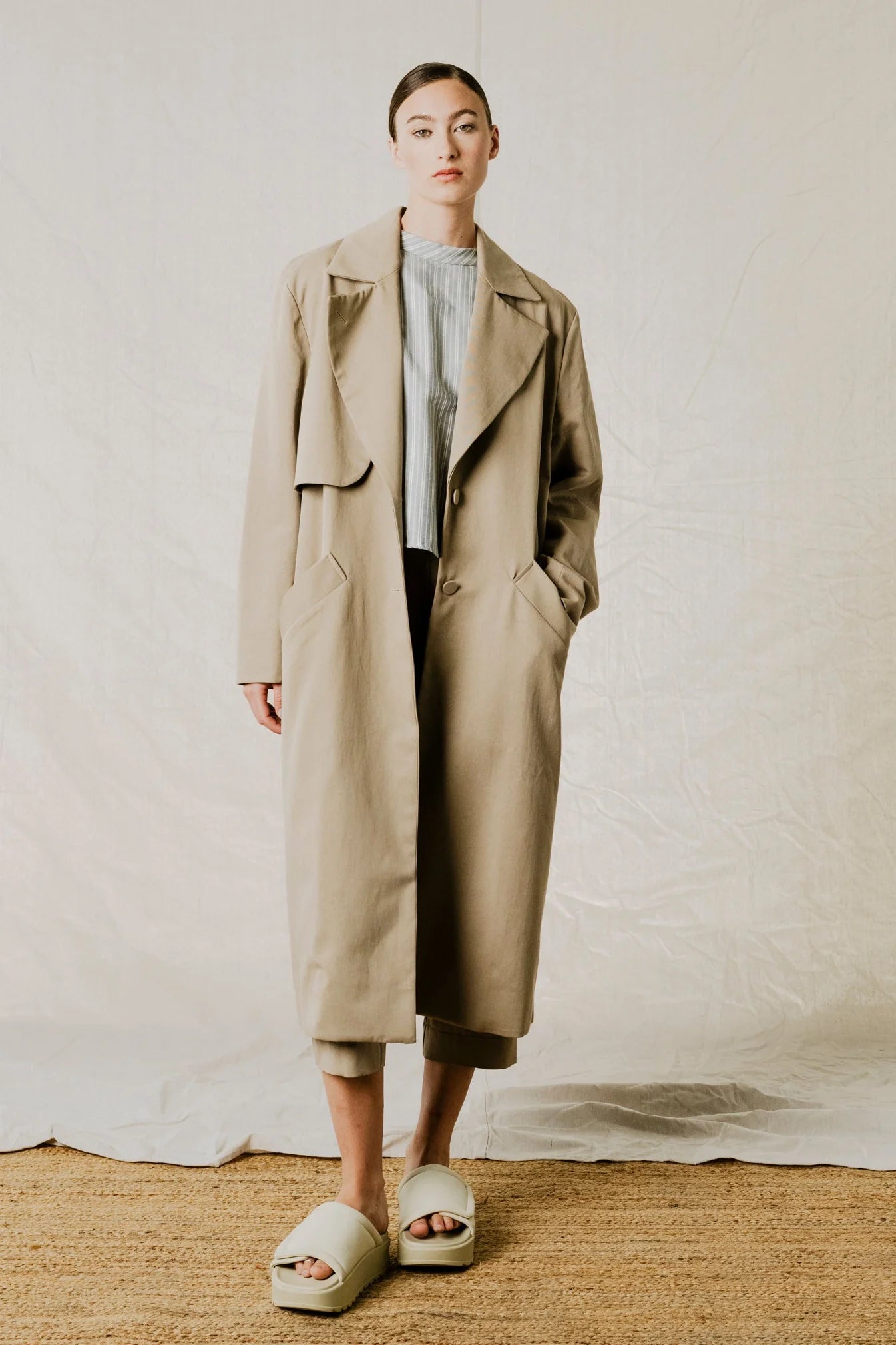 lifestyle front view of District Trench Coat in Beige by Bodybag by Jude — oversized Tencel-cotton trench with removable belt, available in Kelowna at Textile Apparel