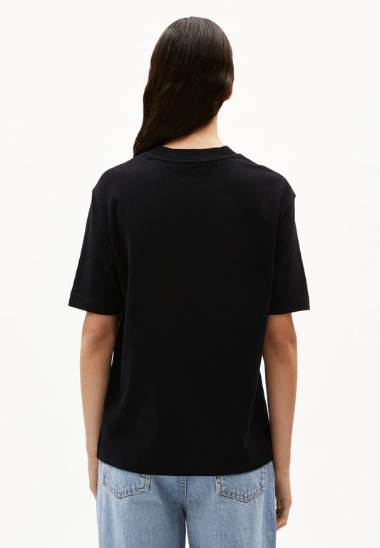 Person wearing a black t-shirt and light blue jeans on a white background