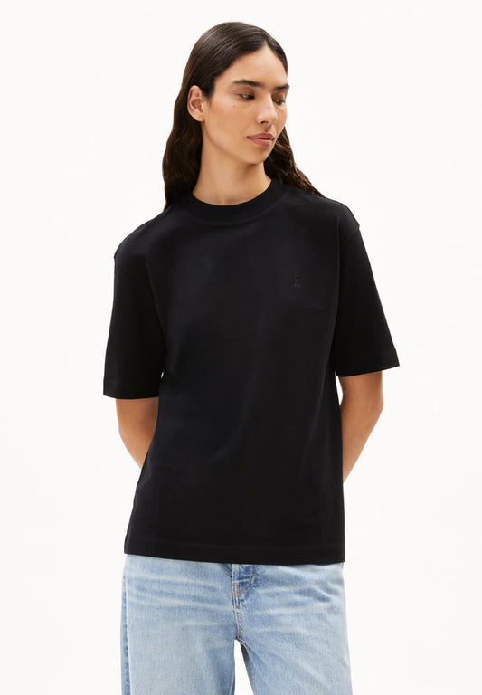 Person wearing a black t-shirt and light blue jeans on a white background