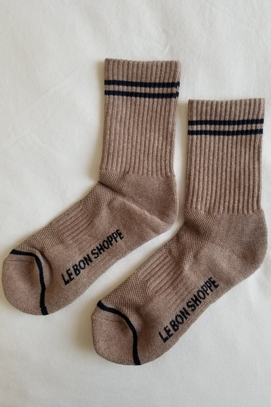 Pair of brown socks with black stripes and 'LEBON SHOPPE' branding on a light background