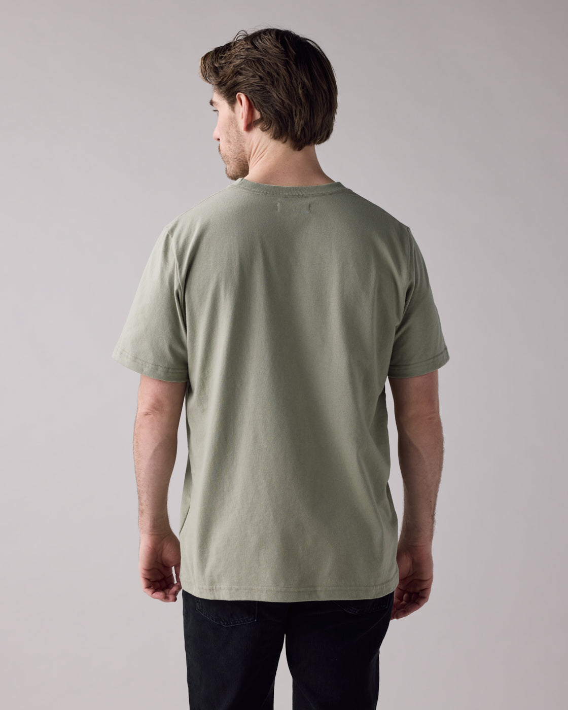 Back view of Anian men's unisex olive green t-shirt on model relaxed fit crew neck in Kelowna