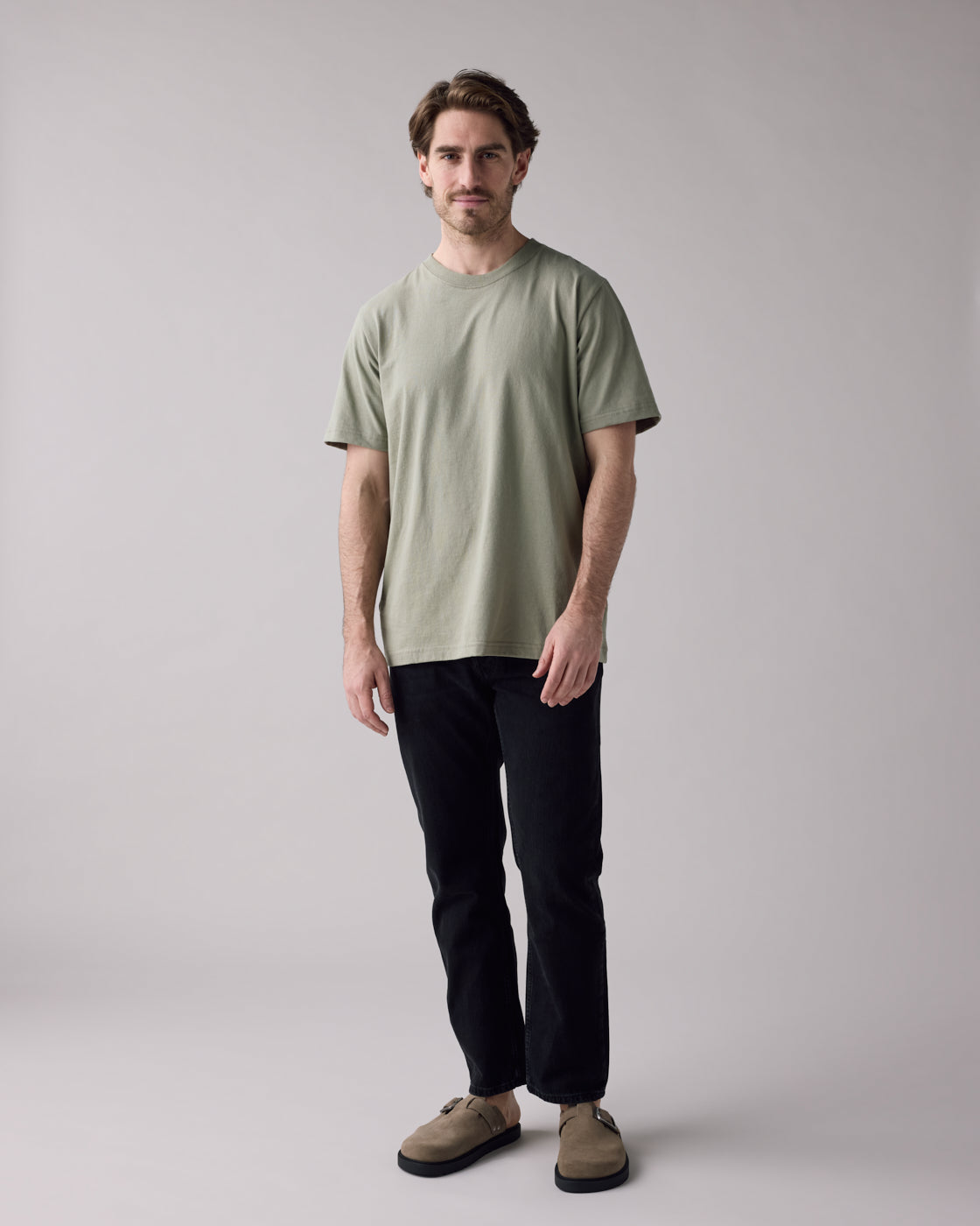 Anian mens unisex relaxed fit olive green t-shirt worn by model with black jeans in kelowna