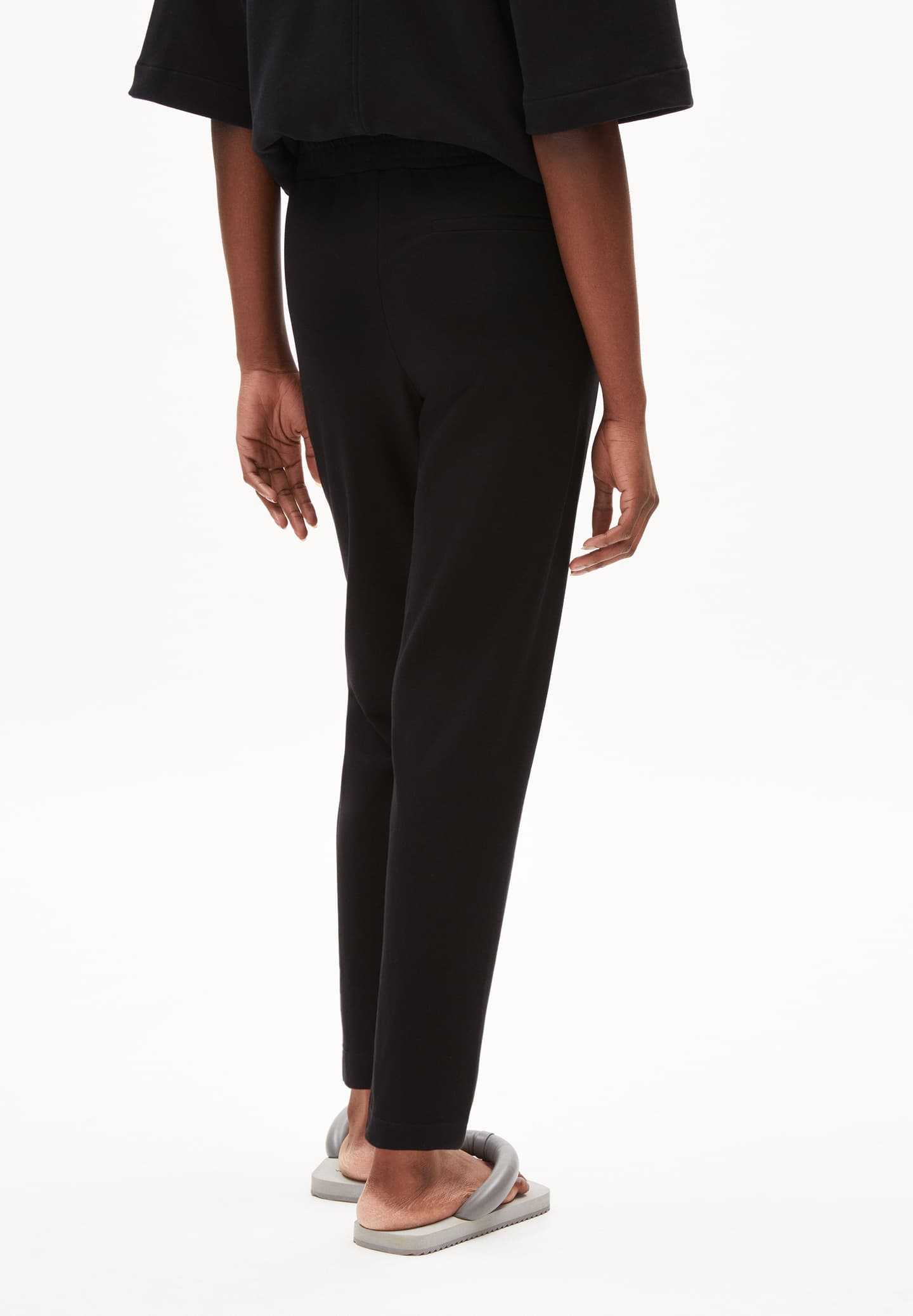 ARMEDANGELS Canada black slim fit pants worn by a model with casual gray sandals