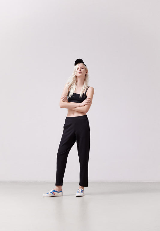 ARMEDANGELS Canada black slim fit pants worn by woman with black crop top and sneakers in Kelowna