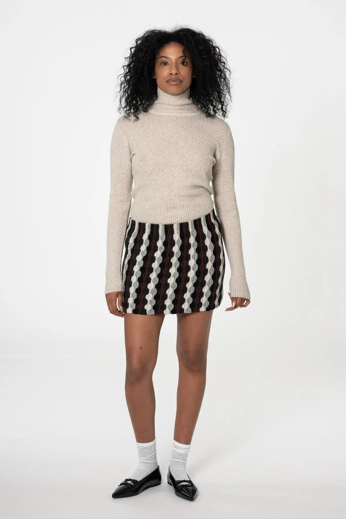 Dinadi merino turtleneck sweater in beige paired with a stylish patterned mini skirt in Kelowna and Canada