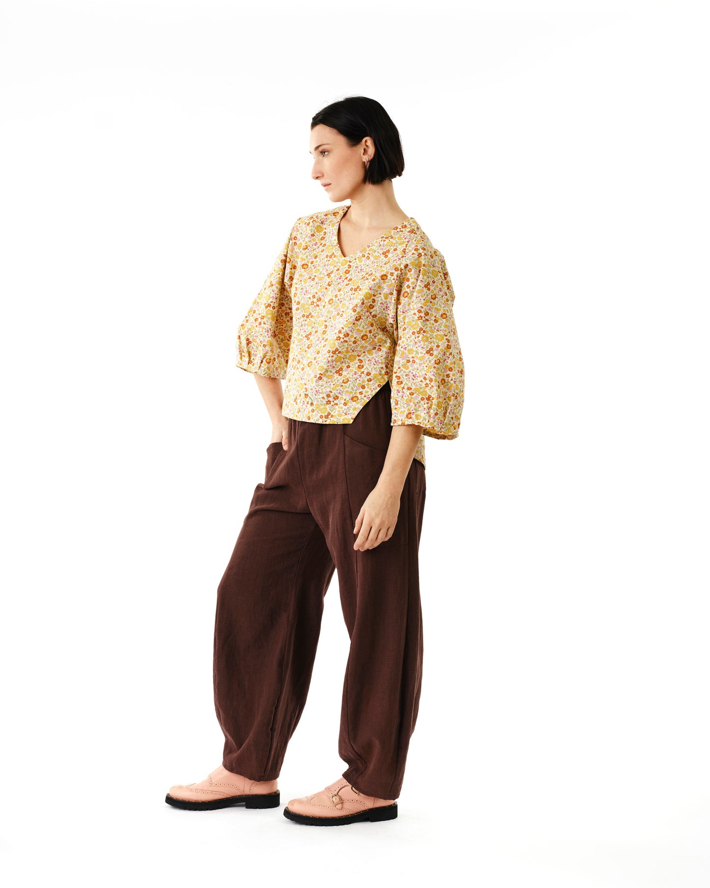 Jennifer Glasgow Design model wearing a floral yellow v neck blouse with balloon sleeves and relaxed brown linen pants in Kelowna