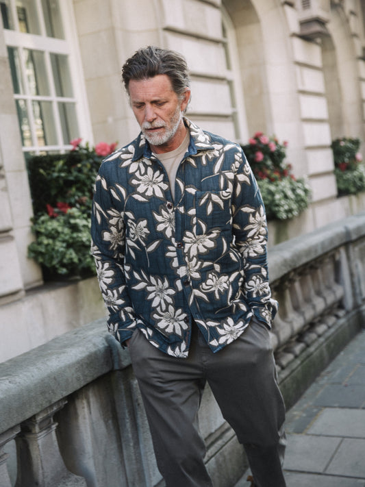 Older man wearing Mos Mosh Gallery vintage indigo overshirt with white floral print over cream tee on city sidewalk in Kelowna