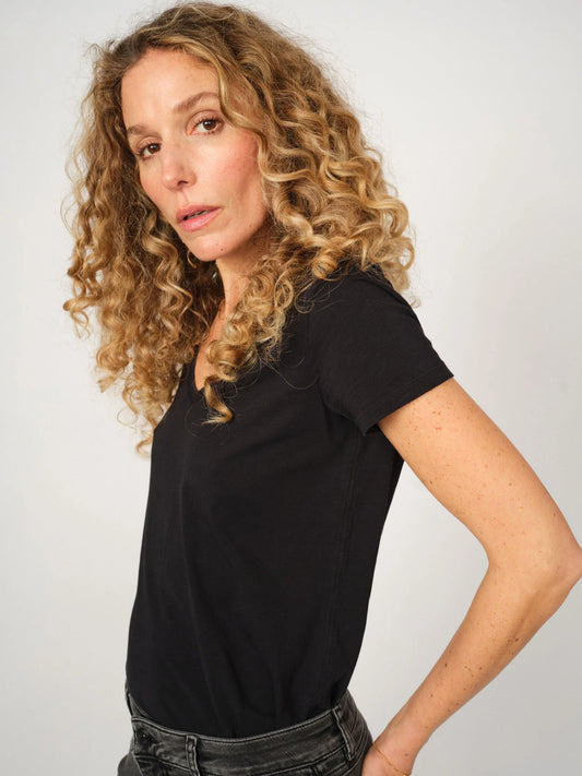 Womens black organic cotton V-neck t-shirt by MOS MOSH Canada modeled with curly hair and jeans in Kelowna