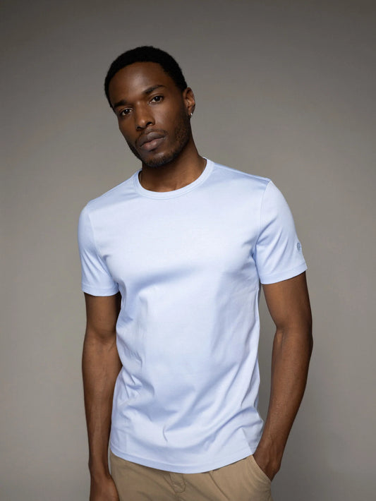 Mens model wearing organic light blue t-shirt by Mos Mosh Gallery slim crew neck casual outfit with khaki pants in Kelowna