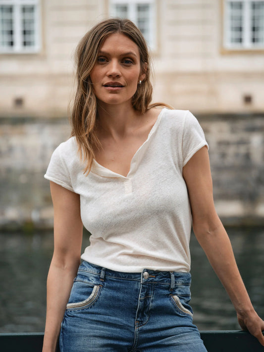 MOS MOSH Canada white lightweight short sleeve t-shirt on woman tucked into blue jeans by historic building in Kelowna