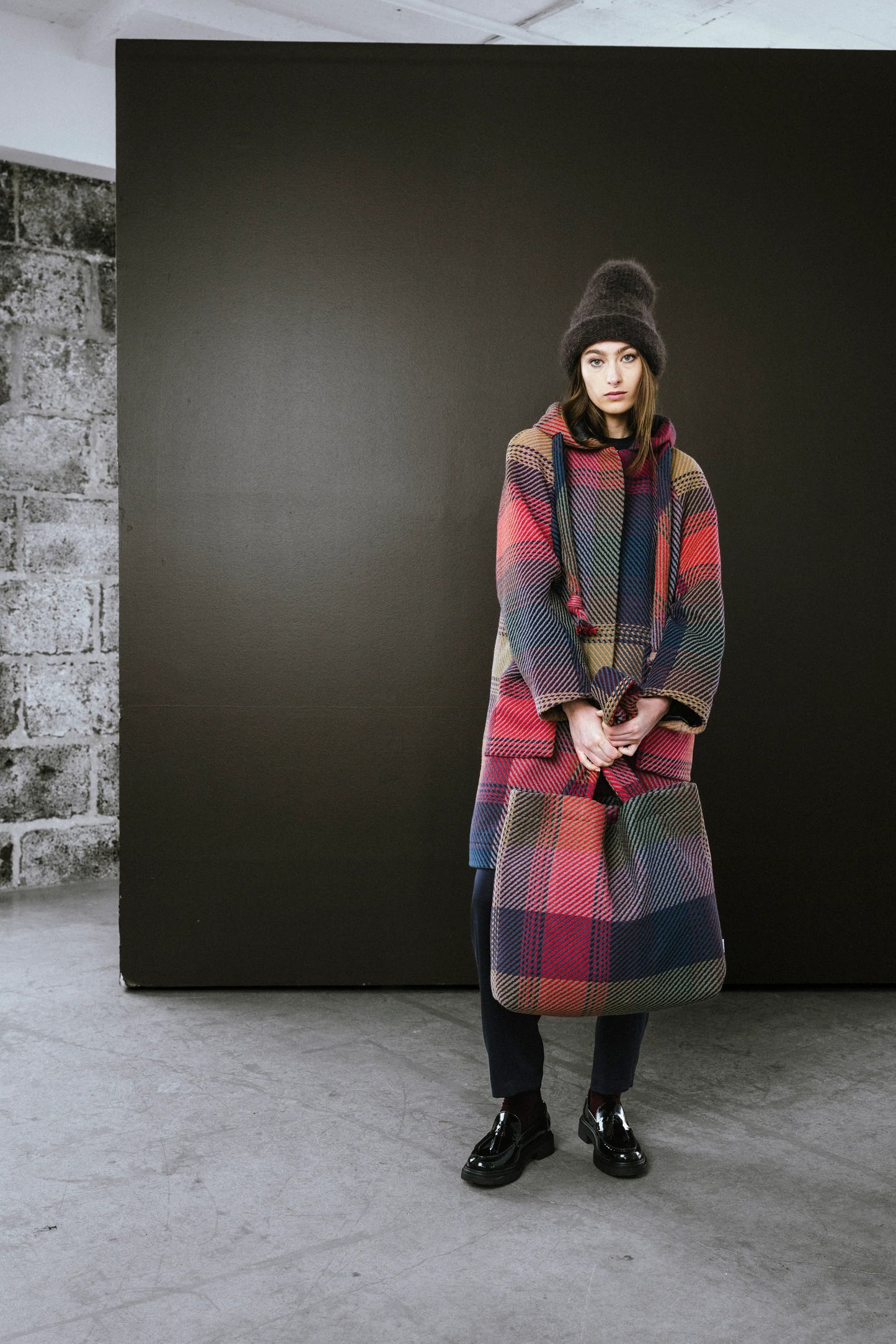Stylish BodyBag by Jude tote bag displayed with a model in a colorful coat and hat in Kelowna