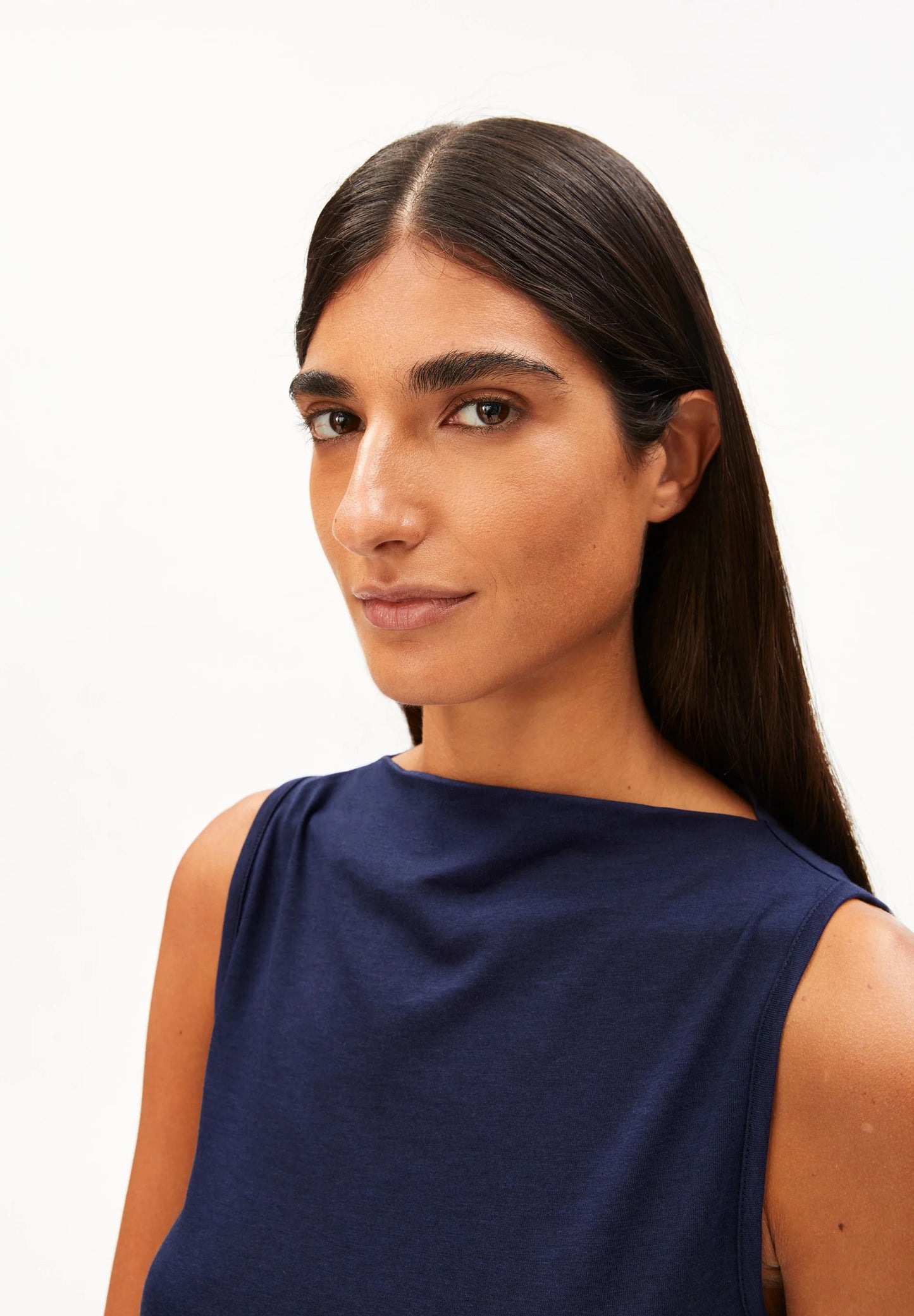 woman wears navy top against white background