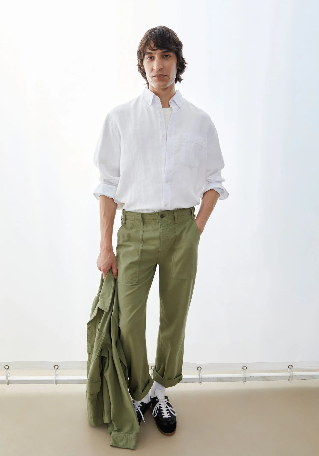 styled with green jacket and pants it's the Men's LINEN LONGSLEEVE SHIRT - ARMEDANGELS Canada in white on model in Kelowna