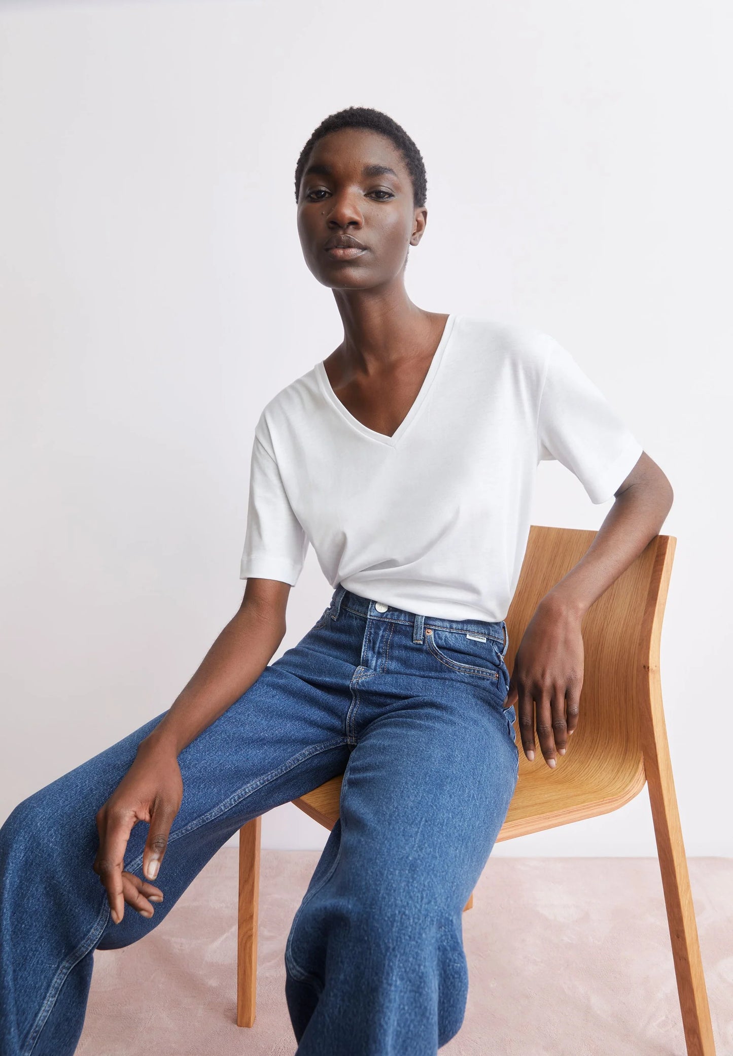 Style shot of model in white tee - V-Neck T-Shirt – ARMEDANGELS Canada white t-shirt v-neck