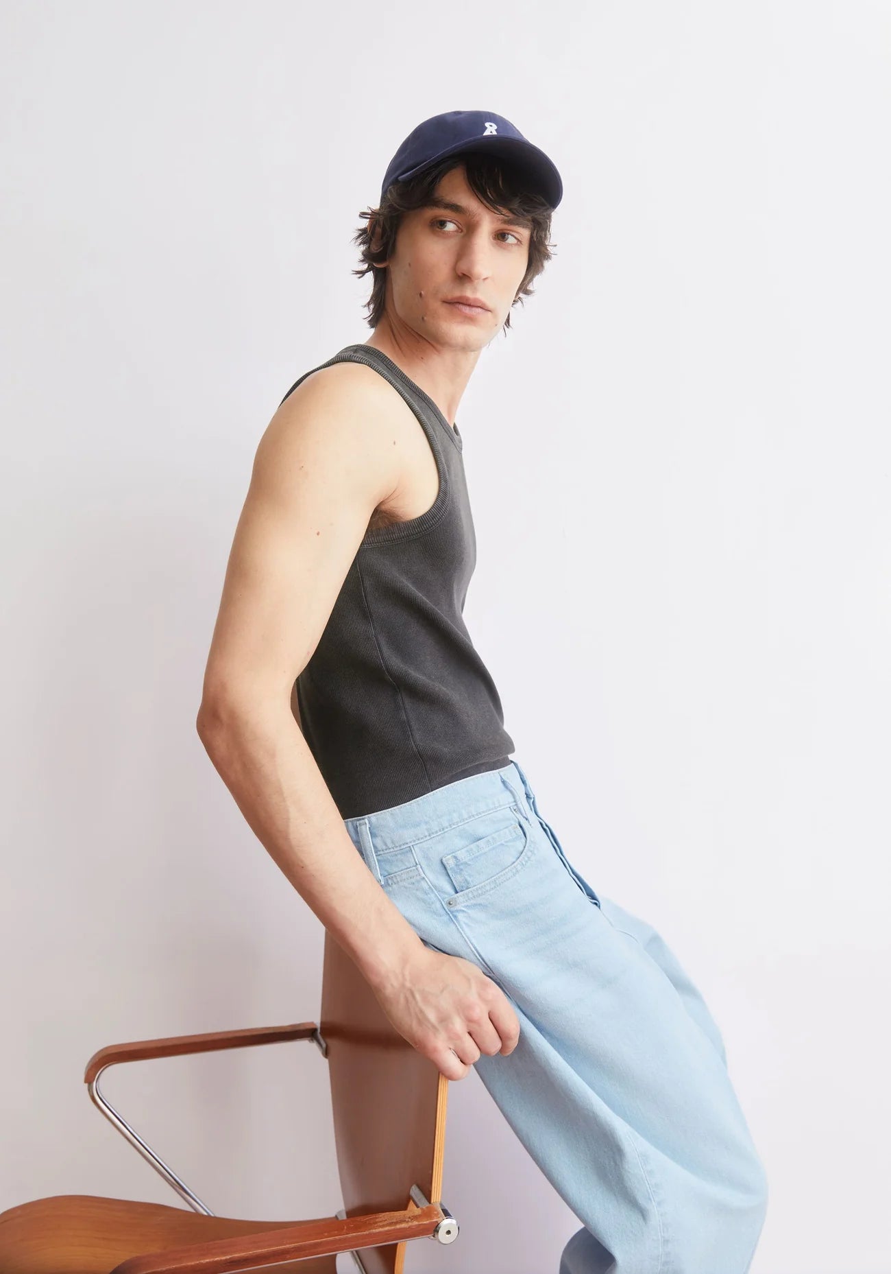 GMT DYE TANK TOP in Black-wash - ARMEDANGELS Canada garment dye black men's tank top side view styled on a model with baseball cap and jeans