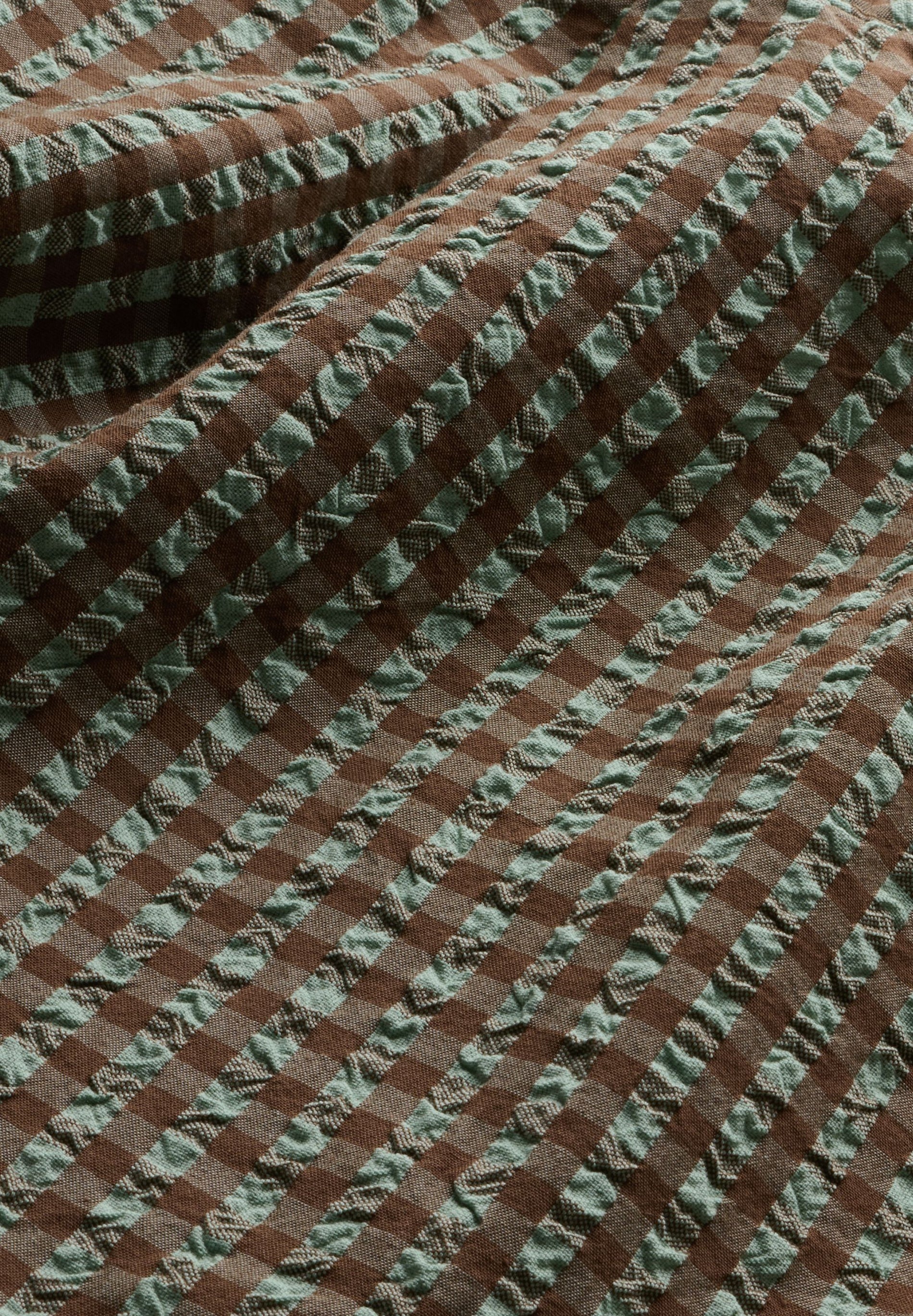 Detail shot of brown and green checkered vichy seersucker fabric