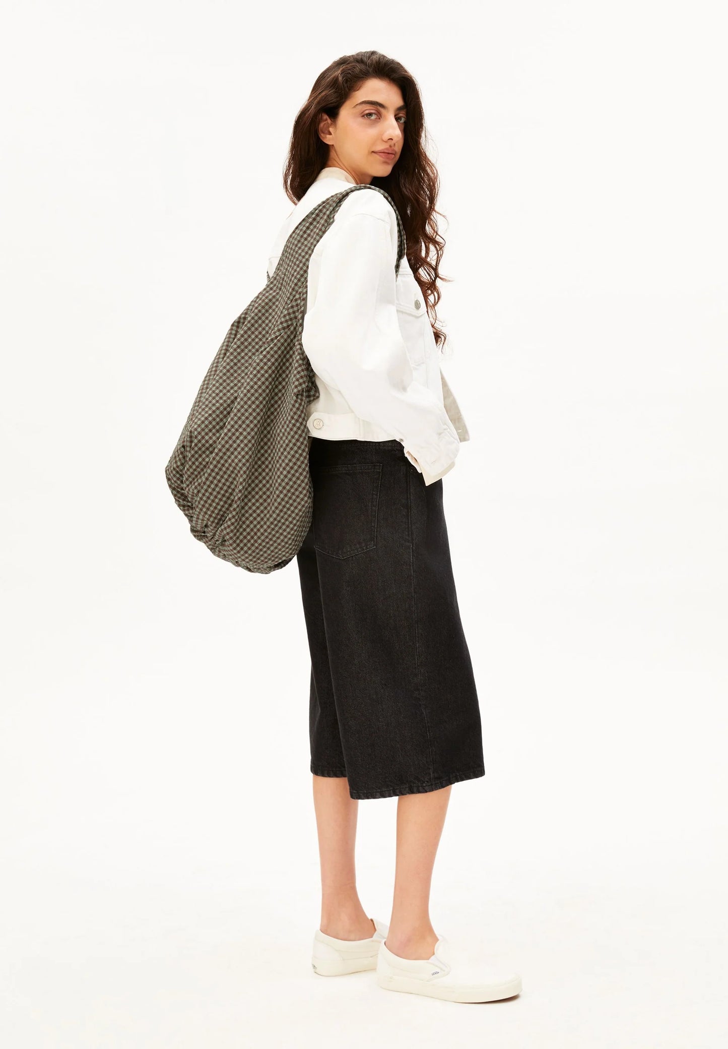 Model, full side shot, holding brown and green checkered bag for Kelowna and Canada