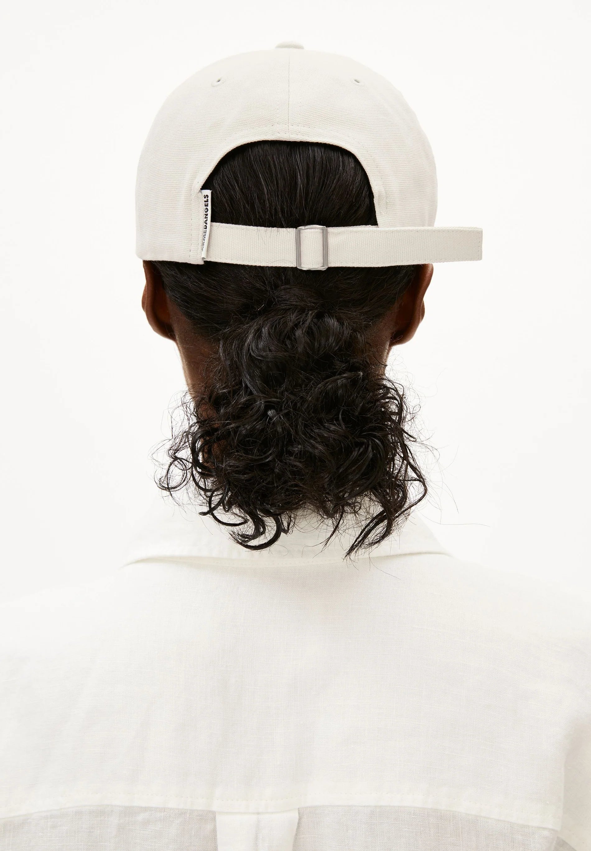 Person wearing a white cap and white shirt on a white background