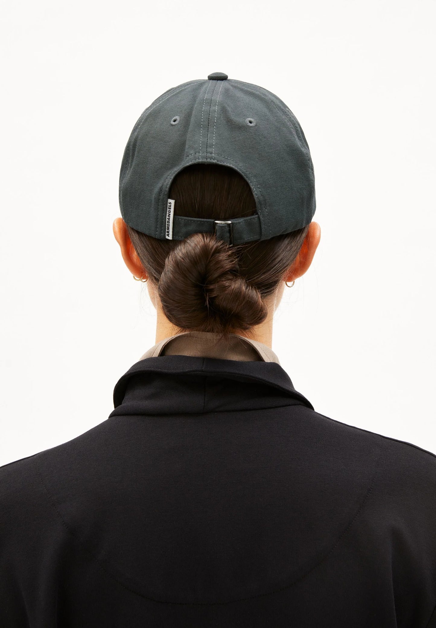 Person wearing a gray cap from behind on a white background