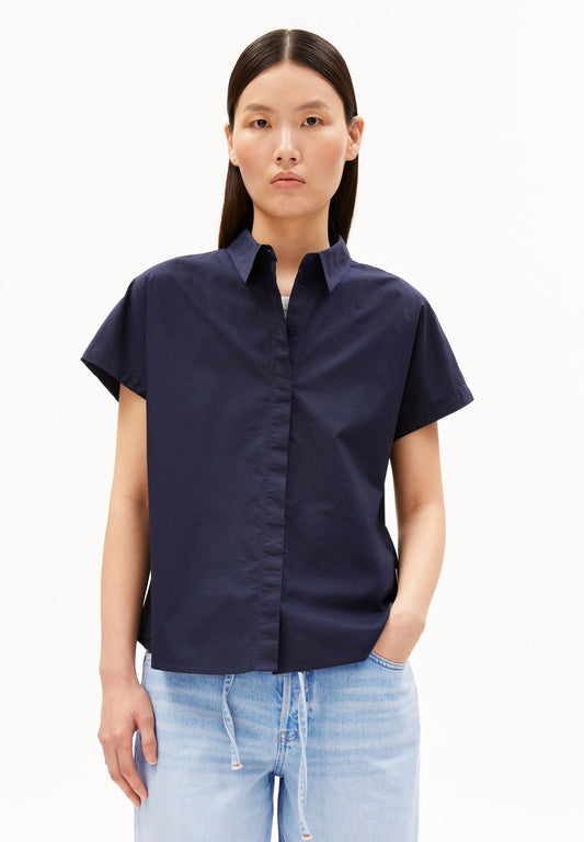 Woman wearing a navy blue shirt and light blue jeans on a white background for Kelowna and Canada