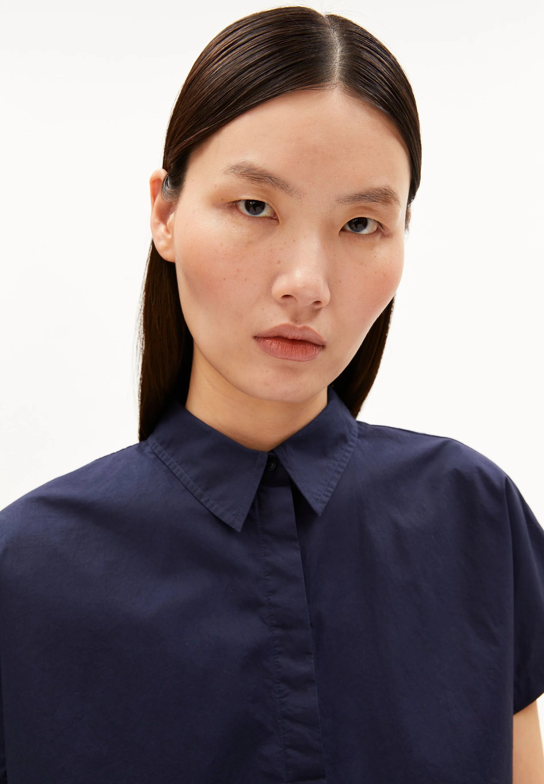 Model wearing a navy blue shirt against a white background for Kelowna and Canada