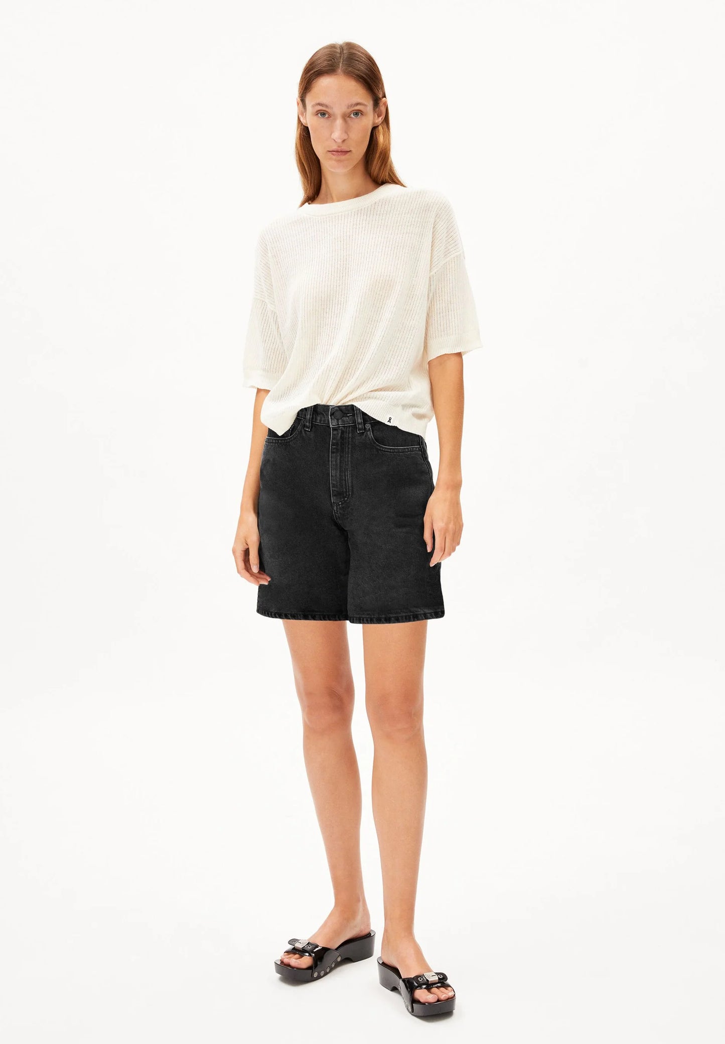Woman wearing a white top and black shorts on a white background for Kelowna and Canada