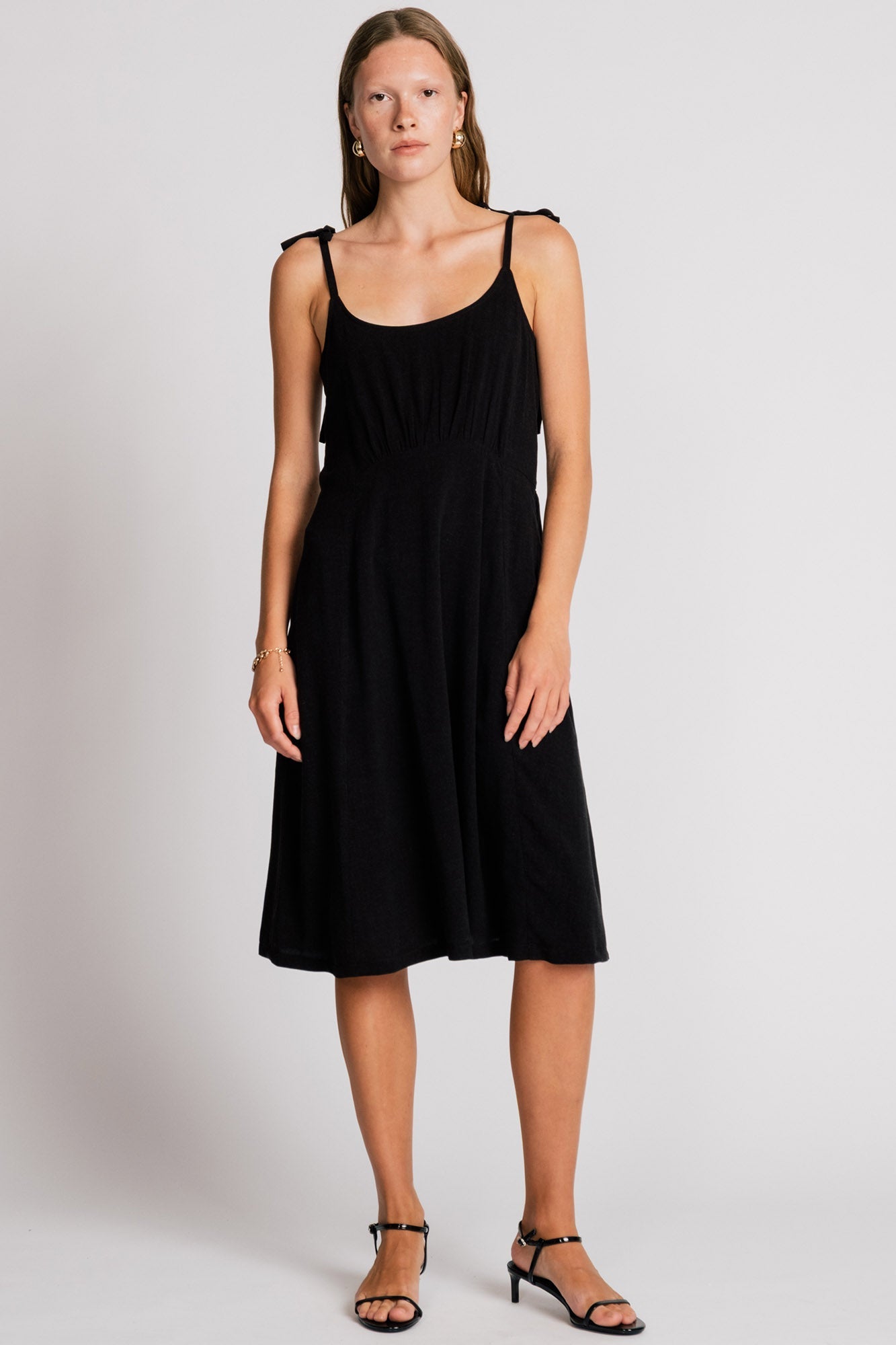 Allison Wonderland Manakin Dress in black, front view on model, available at Textile Apparel Kelowna