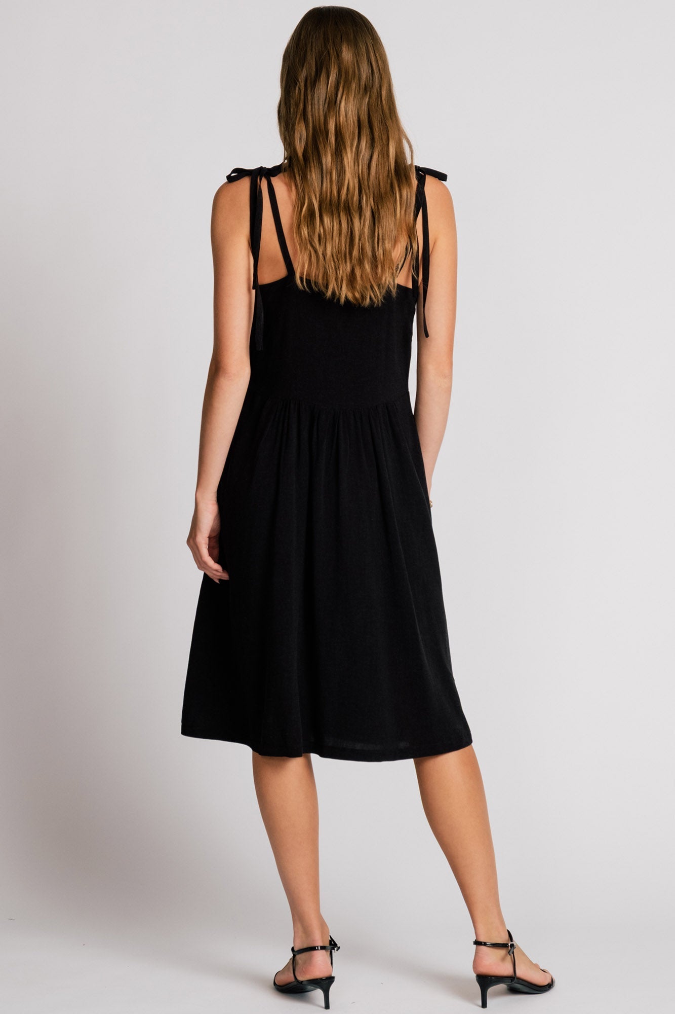 Allison Wonderland Manakin Dress in black, full length back shot on model in Kelowna