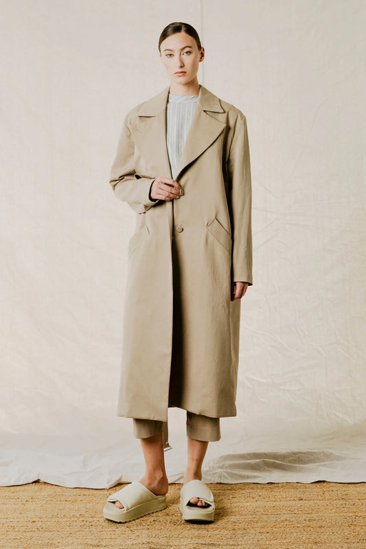 Front view on model of District Trench Coat in Beige by Bodybag by Jude — oversized Tencel-cotton trench with removable belt, available in Kelowna at Textile Apparel