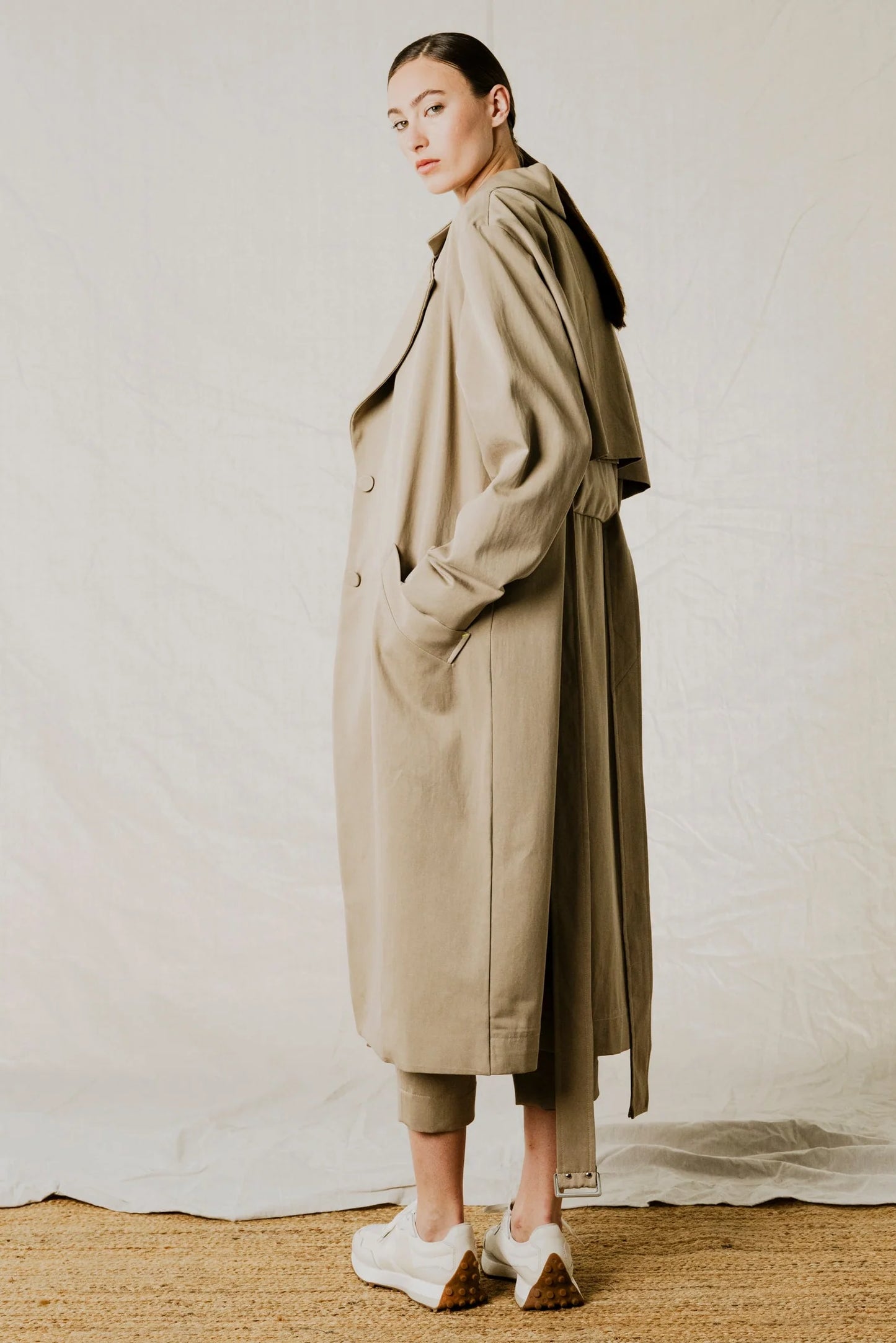 back and side view on model of District Trench Coat in Beige by Bodybag by Jude — oversized Tencel-cotton trench with removable belt, available in Kelowna at Textile Apparel
