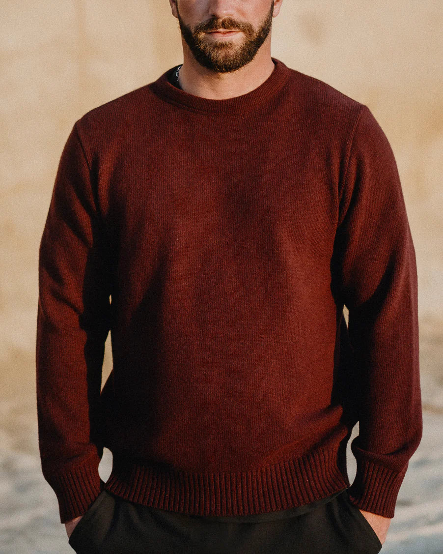 Man wearing a maroon sweater with a blurred background