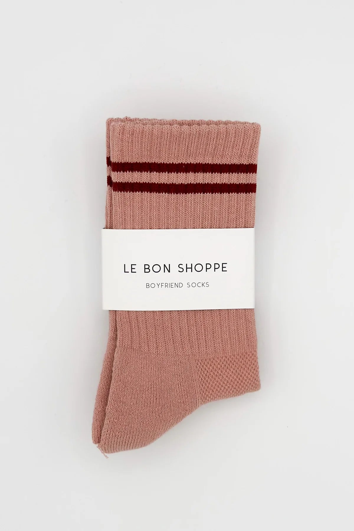 Pair of pink socks with brown stripes and 'Le Bon Shoppe' label on a white background