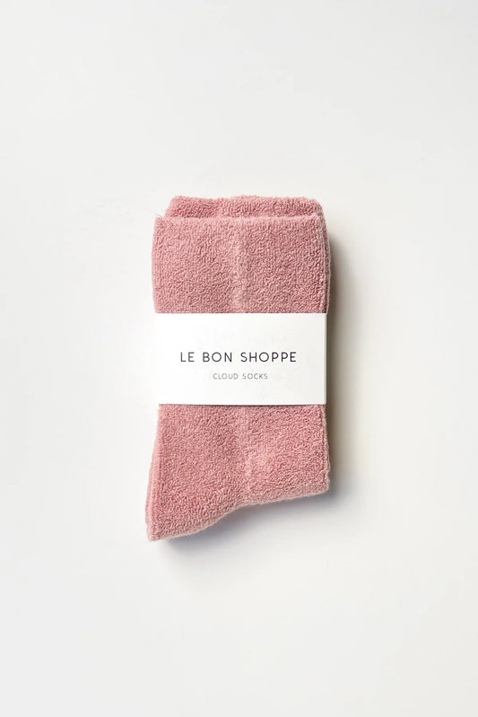 Folded pink socks with a white label on a light gray background