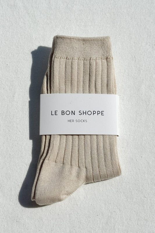 Pair of beige socks with a 'Le Bon Shoppe' label on a light gray background