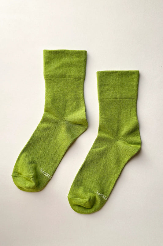 Pair of green socks on a light gray background