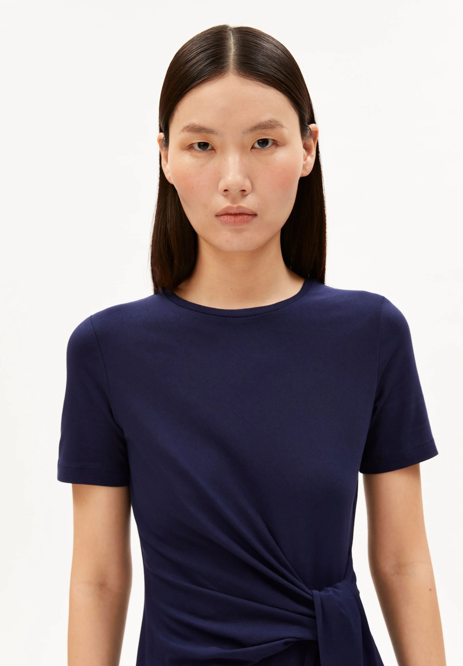 WAIST-UP PHOTO OF NAVY SHEATH WRAP DRESS ON MODEL WITH BLACK HAIR AGAINST WHITE BACKGROUND