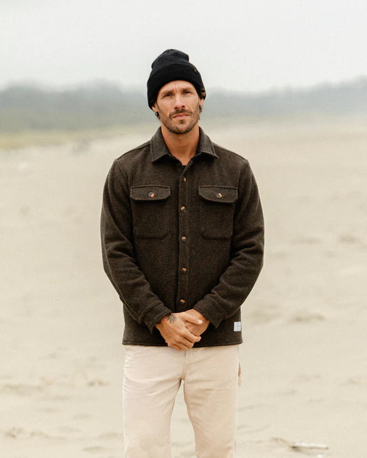 Anian wool coat for men dark brown shirt jacket with flap pockets modeled on windswept beach in Kelowna