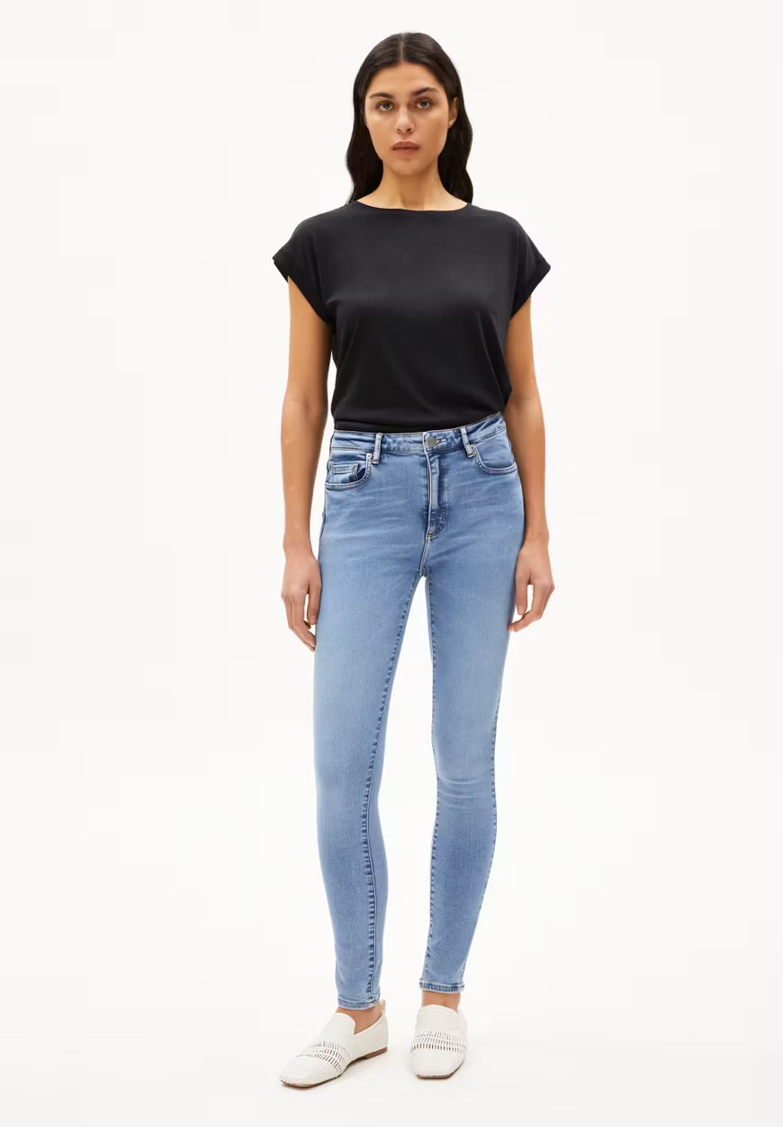 ARMEDANGELS Canada black short sleeve t-shirt paired with light blue skinny jeans and white loafers in Canada