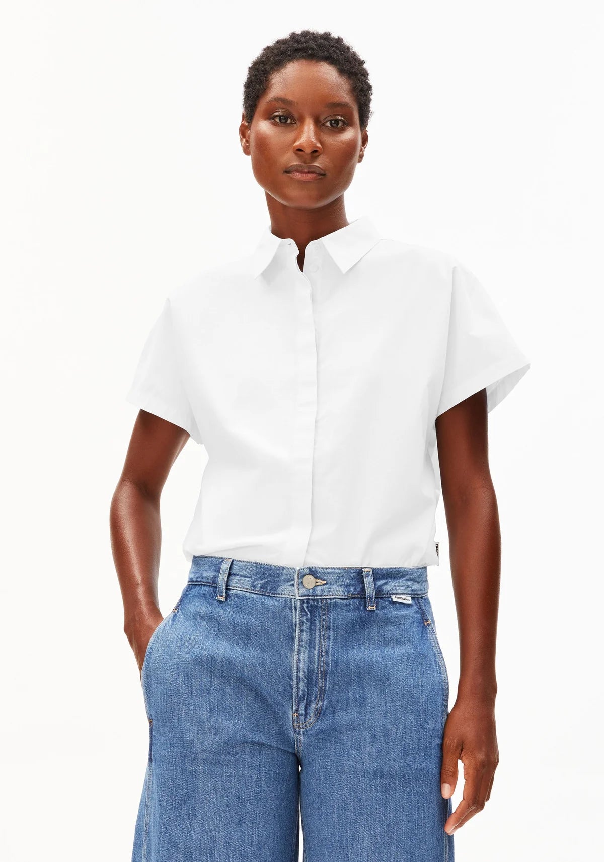 Cropped image of model wearing ARMEDANGELS Canada white poplin collared shirt against a white background
