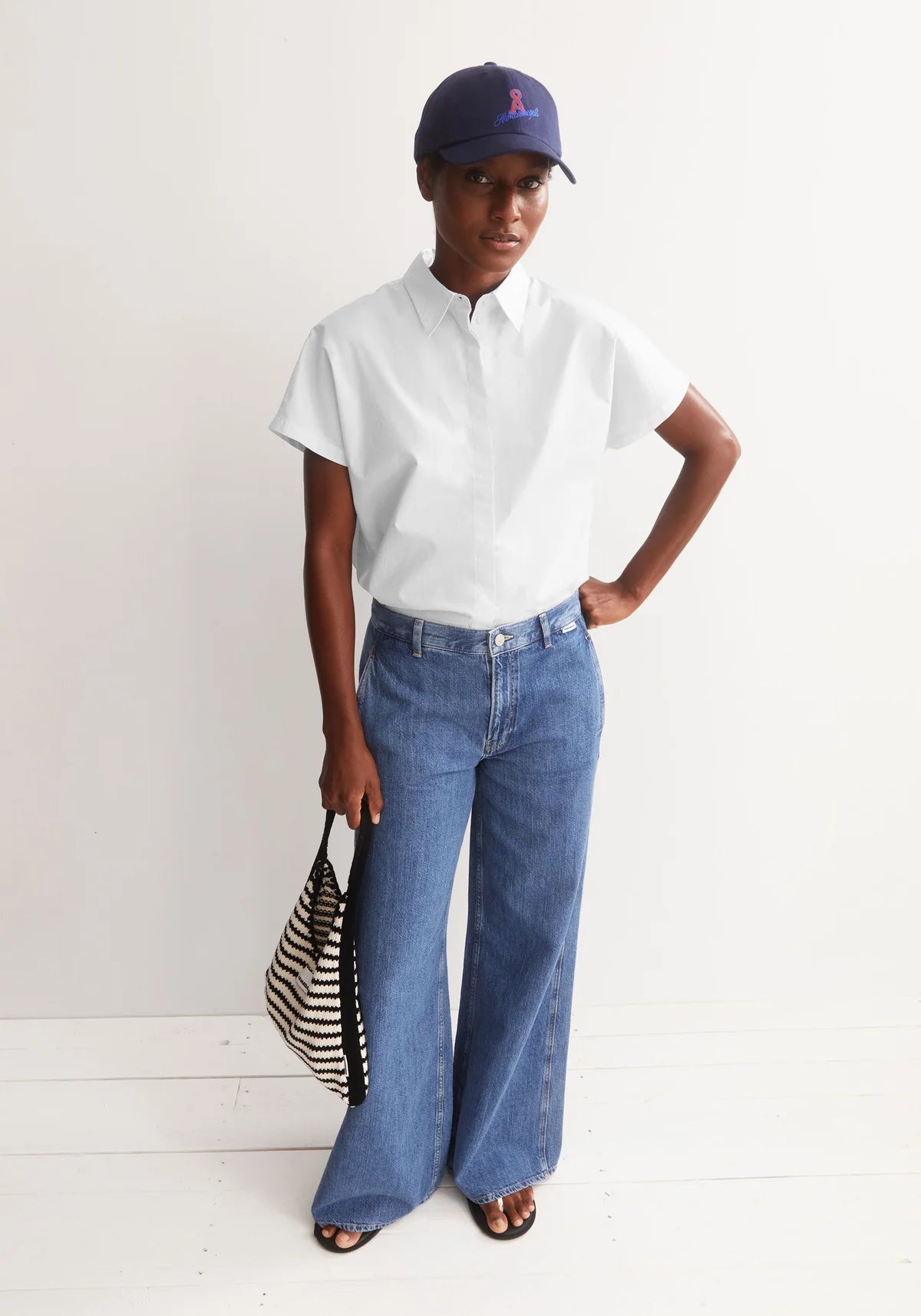 Full front of model wearing ARMEDANGELS Canada white poplin collared shirt against a white background wearing ball cap