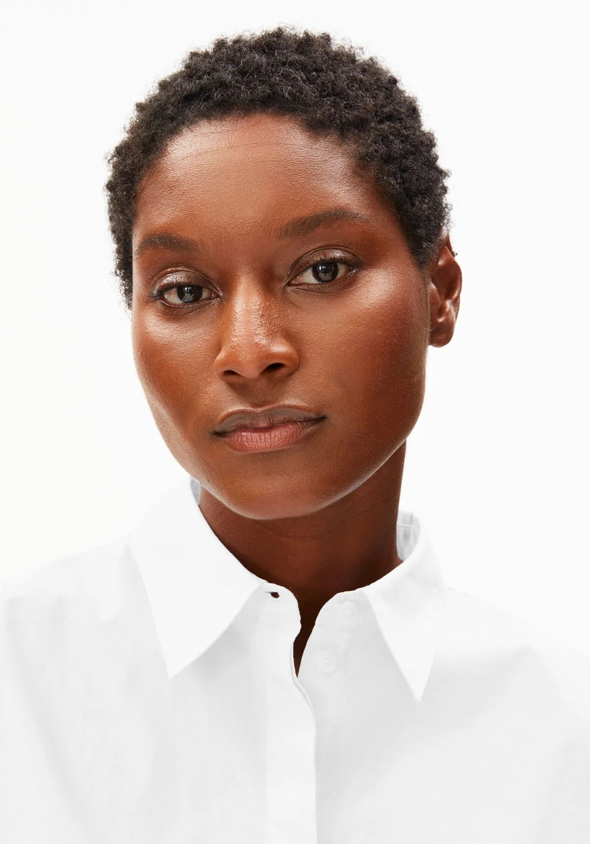 Headshot of model wearing ARMEDANGELS Canada white poplin collared shirt against a white background