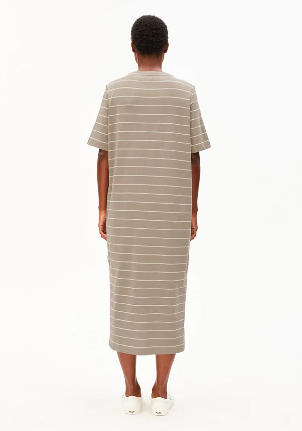 Backside of model wearing ARMEDANGELS Canada long light brown striped t-shirt dress with white background
