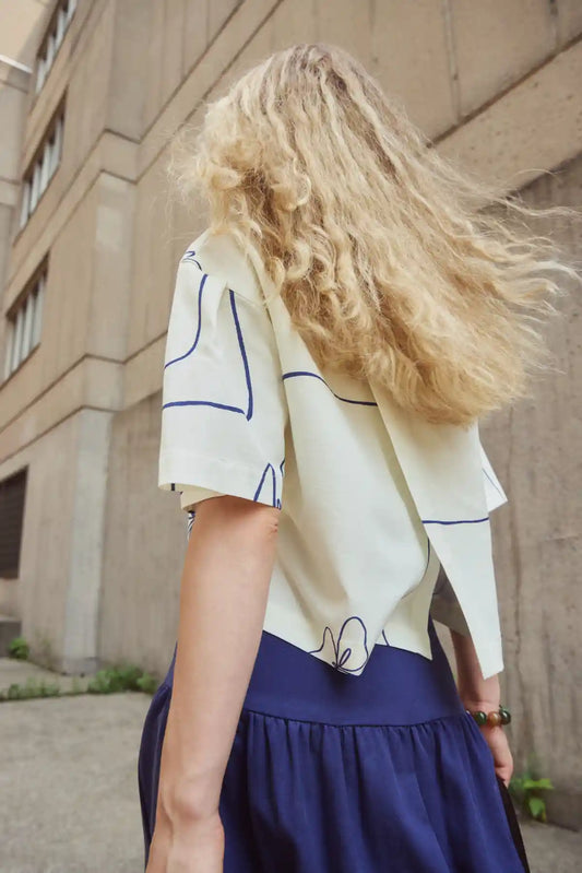Eve Gravel Back View of Light Yellow Blouse with Flowing Design and Blue Accents