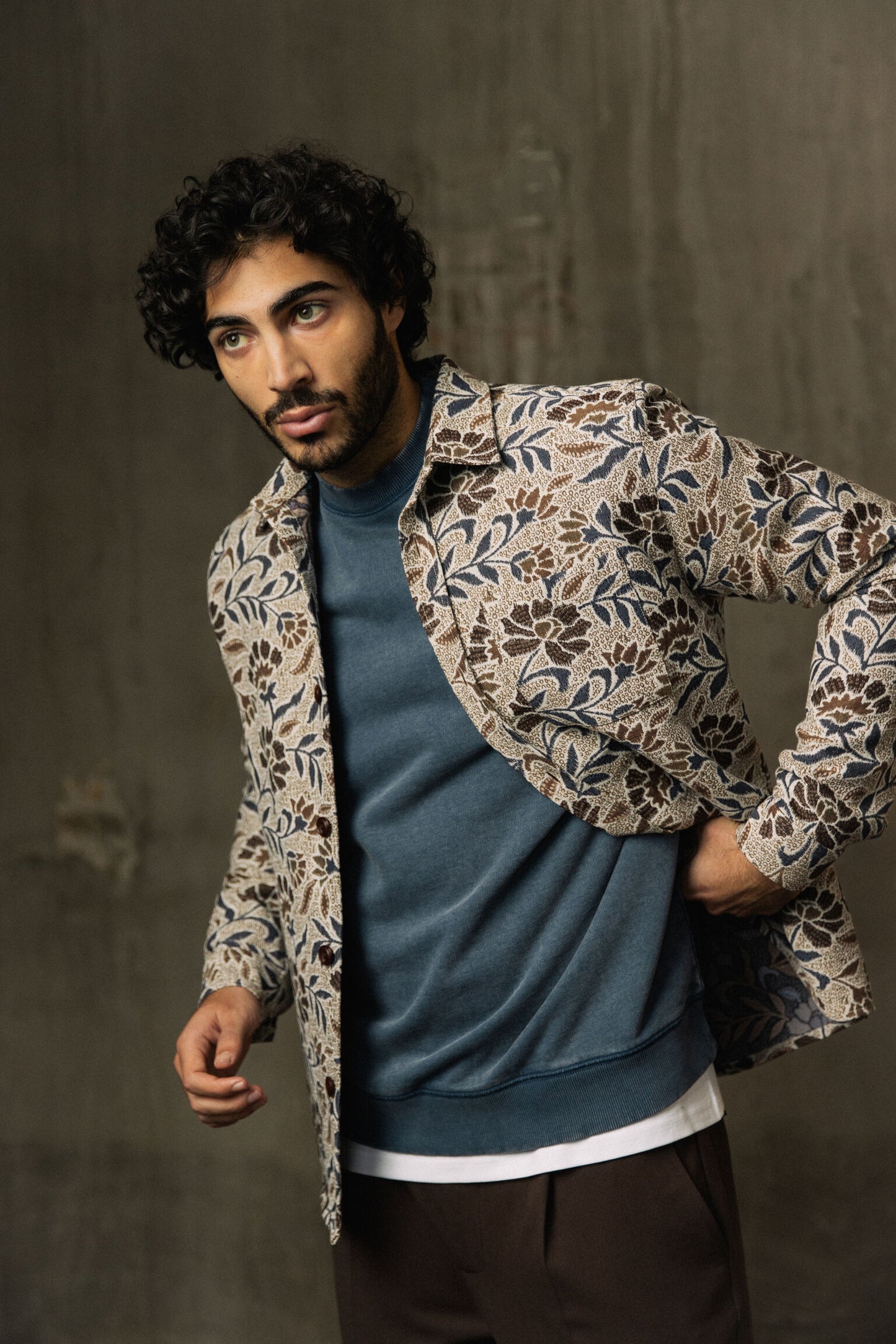 Male model wearing organic men's overshirt with blue sweater layered over white tee and brown pants in Kelowna