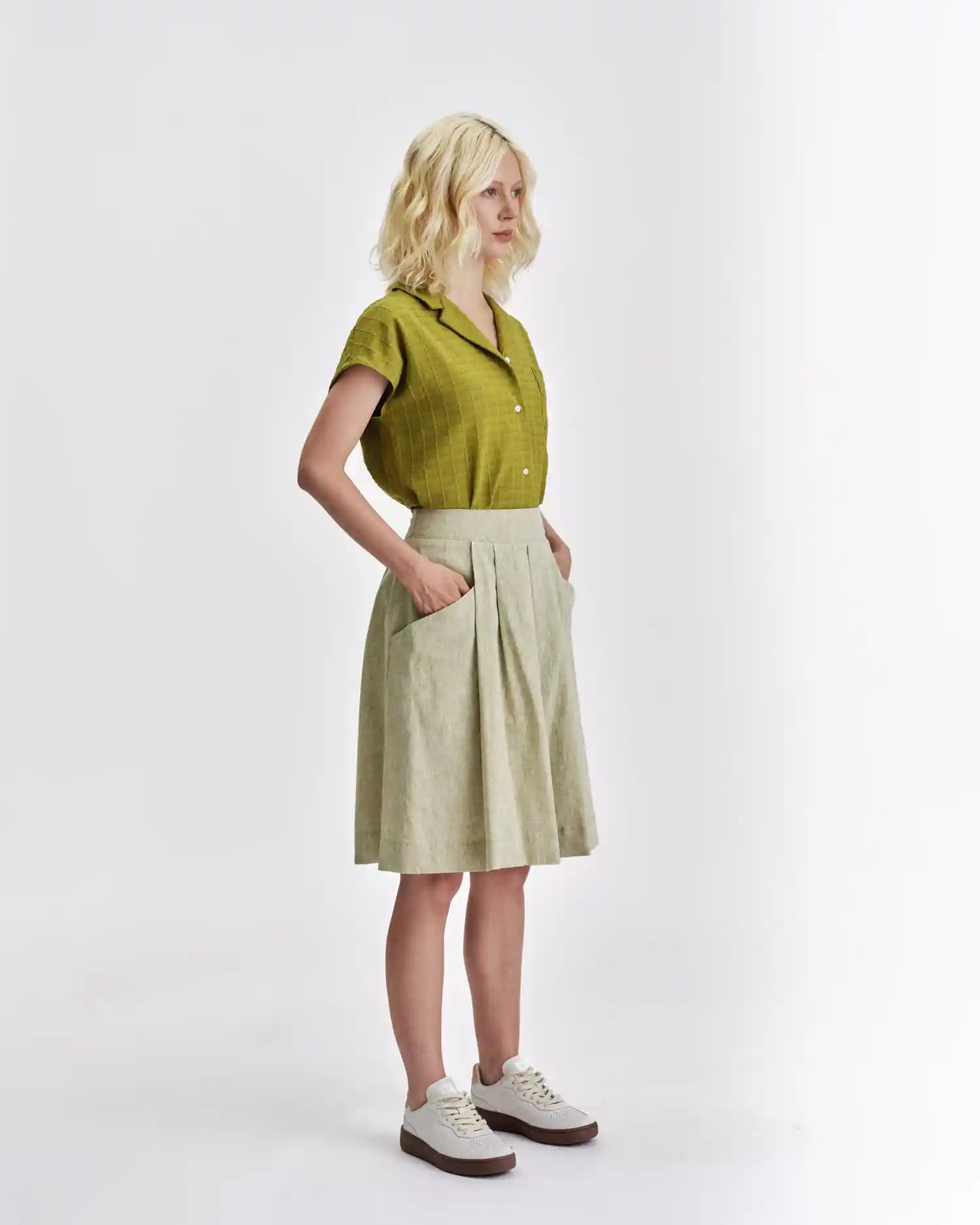 Stylish Jennifer Glasgow Design top in green with short sleeves and button details, paired with a light skirt