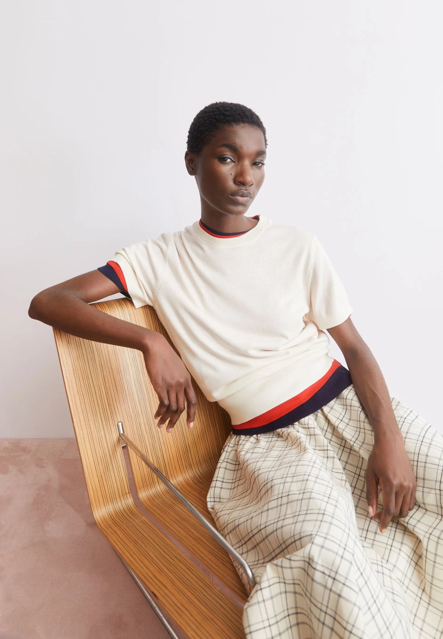 ARMEDANGELS Canada - FINE Knit Sweater in Oatmilk model sitting on a chair in short sleeve sweater