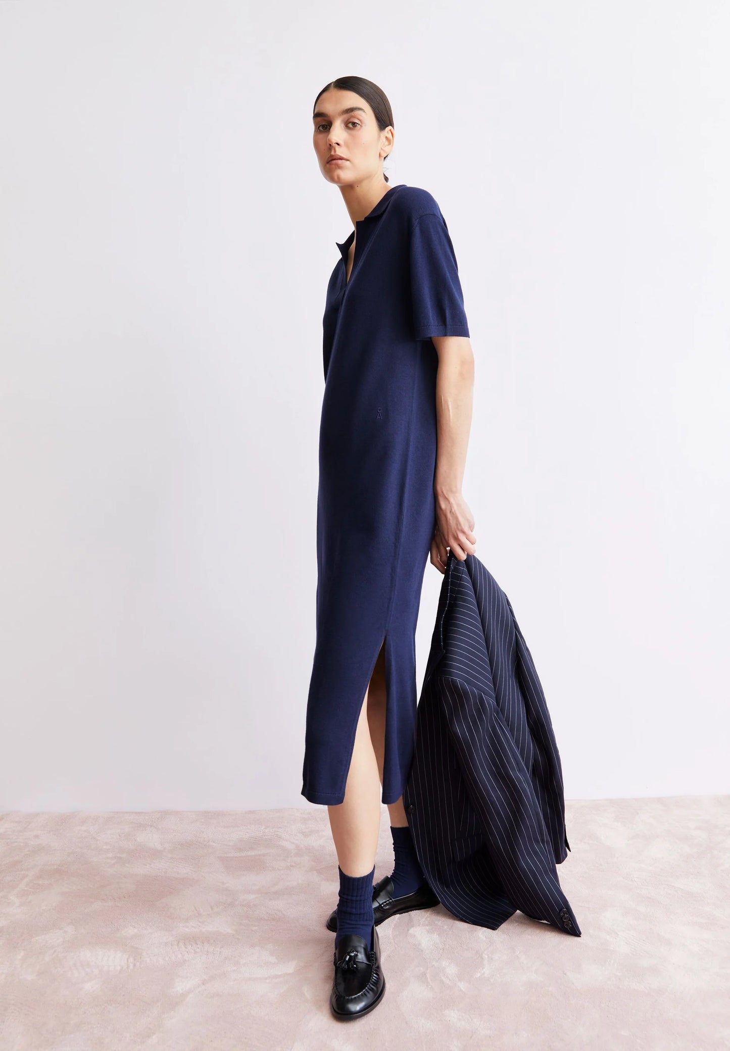 ARMEDANGELS Canada - FINE Polo Knit Dress in Tinted Navy - model shot carrying a jacket